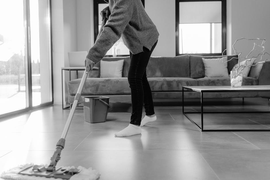 A person using a mop to clean the floor